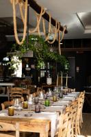 イェーゾロにあるCamoma Aparthotel - Suites Apartmentsの白いテーブルと椅子が備わるレストランの長テーブル