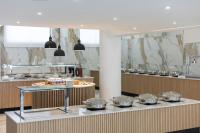 uma cozinha com muitas panelas e frigideiras num balcão em Papouis Protaras Hotel em Protaras