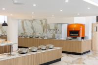 uma cozinha com uma fileira de bancadas com panelas de prata em Papouis Protaras Hotel em Protaras