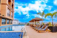 Una piscina de hotel con tumbonas y un cenador. en M Hotel Kigali, en Kigali