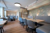 ein Restaurant mit Holztischen und blauen Stühlen in der Unterkunft Gästehaus am Tiergarten in Raesfeld