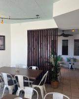 a dining room with a table and white chairs at El Coronado Resort in Wildwood Crest