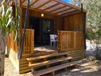 une cabane en bois avec un banc et une table dans l&#39;établissement Camping La Pinède, à Calvi