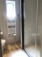 La salle de bains est pourvue d&#39;une douche, de toilettes et d&#39;une fenêtre. dans l&#39;établissement Camping La Pinède, à Calvi