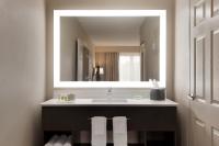 ein Badezimmer mit Waschbecken und großem Spiegel in der Unterkunft Holiday Inn Hotel &amp; Suites Council Bluffs by IHG in Council Bluffs