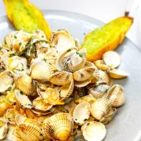 a plate of shells and a pickle on a table at Hôtel-Restaurant La Mascotte in La Baule