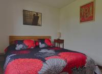 a bedroom with a bed with a red and black blanket at Le Logis d&#39;Emeric Confortable&amp;Fonctionnel avec jardin Clos&amp;Arboré in Loches