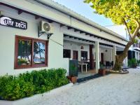 a white building with a sign that reads off diet at Surf Deck in Thulusdhoo