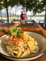 een bord pasta met wortelen op tafel bij Pasir Putih Cottage - Menjangan in Banyuwedang