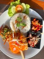 een bord met rijst, vlees en groenten bij Pasir Putih Cottage - Menjangan in Banyuwedang