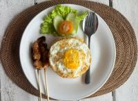 een bord voedsel met een ei en groenten bij Pasir Putih Cottage - Menjangan in Banyuwedang