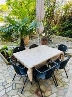 a table with chairs and an umbrella on a patio at Apartments Lavanda 1 in Njivice