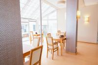 a dining room with tables and chairs and windows at Hotel am Park Bad Driburg in Bad Driburg