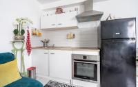 a kitchen with white cabinets and a black refrigerator at Cozy Apartment In St Thibault Des Vignes With Kitchenette in Saint-Thibault-des-Vignes