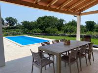 a patio with a table and chairs and a swimming pool at Villa Yucca Istra in Labin
