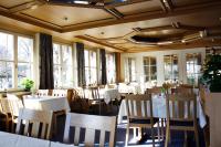 a restaurant with white tables and chairs and windows at Flair Hotel Dobrachtal in Kulmbach