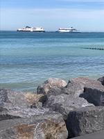 two ships in the ocean with rocks in the water at Sangatte Guest Room - Le Sunset - in Sangatte