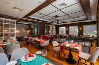 a restaurant with tables and chairs in a room at Sunland Resort Beldibi in Beldibi