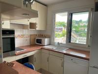 a kitchen with a microwave and a sink and a window at Magnifique appartement avec vue in Chaville
