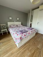 a bedroom with a bed with a floral comforter and a mirror at Villa MA&amp;VA in Lacanau-Océan