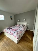 a bedroom with a bed with a floral bedspread at Villa MA&amp;VA in Lacanau-Océan