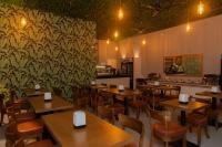 a restaurant with wooden tables and chairs and a wallpaper at SIS Tourist Villa, Mathiveri, Maldives in Mathiveri