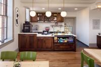 a kitchen with wooden cabinets and green chairs at Hotel Ursa in Orono