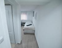 a small white bedroom with a bed and a mirror at Hostel Tuzla in Tuzla