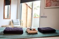 a bed with two purple pillows and a clock on it at Nomads St Kilda in Melbourne