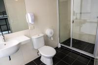 a bathroom with a toilet and a sink and a shower at Nomads St Kilda in Melbourne