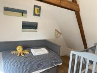 a small room with a crib with a stuffed octopus on it at Les Petites Maisons de la Clarté in Perros-Guirec