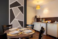 a table with plates and glasses on it in a kitchen at Zenitude Hôtel-Résidences Nantes Métropole in Nantes