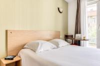Un dormitorio con una cama blanca y una ventana. en Zenitude Hôtel-Résidences Béziers Centre, en Béziers