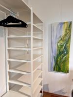 a white shelf in a room with a painting at LUXUS sApartments in der Kunstvilla &amp; kostenloses parken in Premstätten