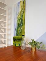 a glass bottle sitting on a wooden table with a painting at LUXUS sApartments in der Kunstvilla &amp; kostenloses parken in Premstätten