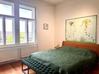 a bedroom with a green bed and two windows at LUXUS sApartments in der Kunstvilla &amp; kostenloses parken in Premstätten