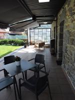Un patio con mesa y sillas y un muro de piedra. en Casas Piedra, en Arredondo