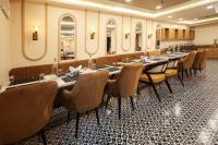 uma fileira de mesas e cadeiras em uma sala com espelhos em Arjun - A boutique hotel em Haridwār