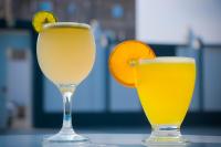 dos vasos de zumo de naranja y una rodaja de naranja en Nesto Hotel, en Manāwirah