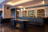 un bar con mesas y taburetes en un restaurante en Pullman Adelaide, en Adelaida