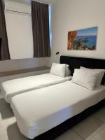 zwei Betten in einem Hotelzimmer mit weißen Laken in der Unterkunft Sun Sea Center in Eilat