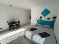 a bedroom with a blue bed and a table at La maison de Giulia Menton in Menton