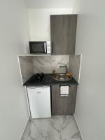 a small kitchen with a sink and a microwave at La maison de Giulia Menton in Menton