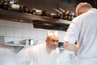 two chefs standing in a kitchen preparing food at Warsaw Presidential Hotel in Warsaw