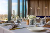 a table with plates and vases with flowers on it at Warsaw Presidential Hotel in Warsaw