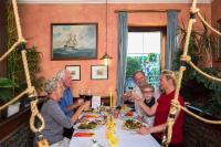 Un grupo de personas sentadas en una mesa comiendo comida en Hotel & Restaurant Hanse Kogge, en Ostseebad Koserow