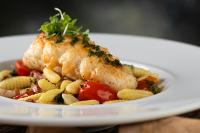 Un plato de comida con un trozo de pescado y pasta. en Hotel Arpoador, en Río de Janeiro