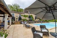 a patio with a pool and chairs and an umbrella at Gîtes et chambres croix du sud in Saint-Amand-de-Vergt