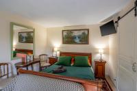 a bedroom with a green bed with a desk and a mirror at Gîtes et chambres croix du sud in Saint-Amand-de-Vergt