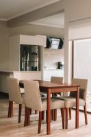 Un comedor con mesa y sillas de madera. en Catriel Suites, en Catriel